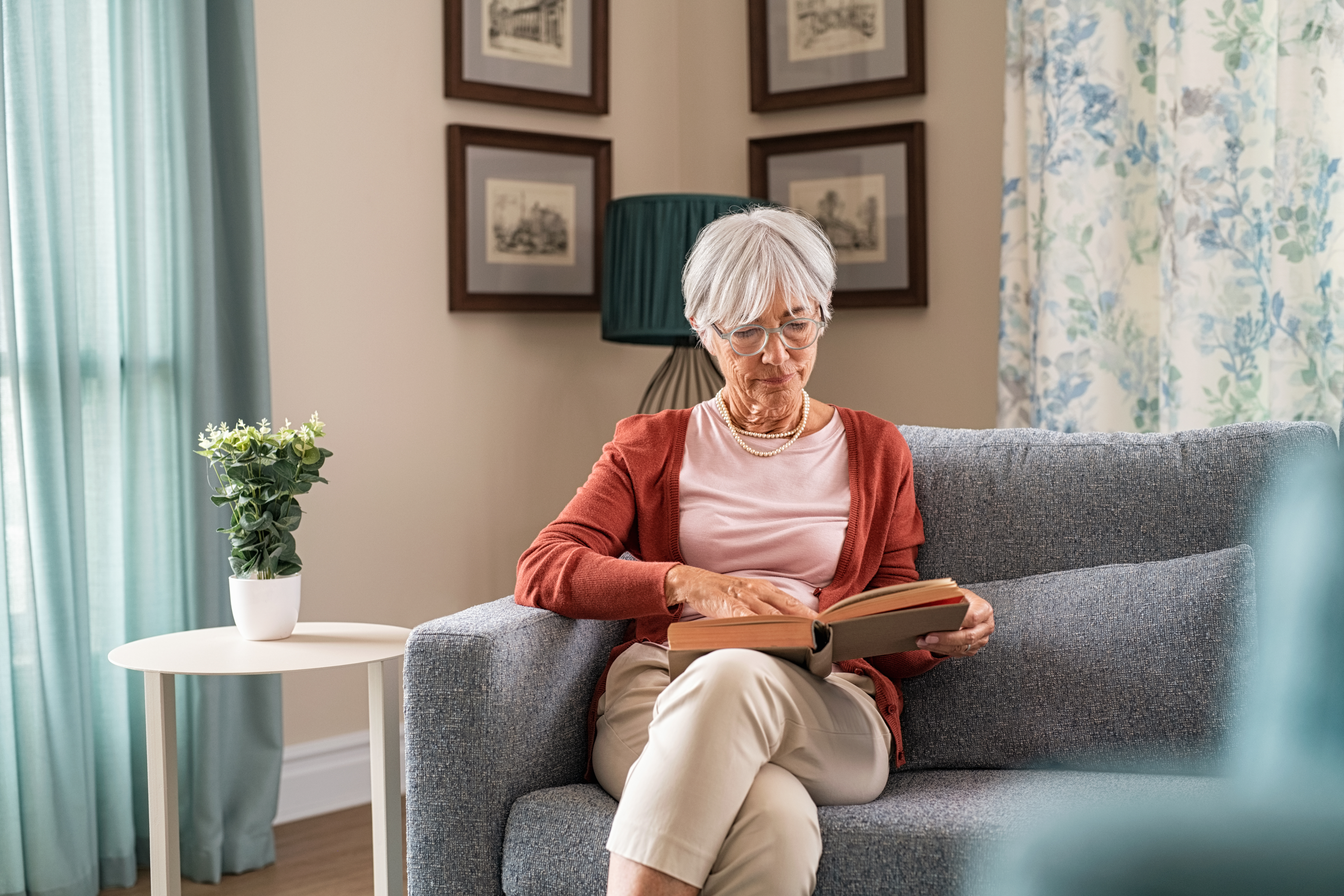 An older woman reading a book at home