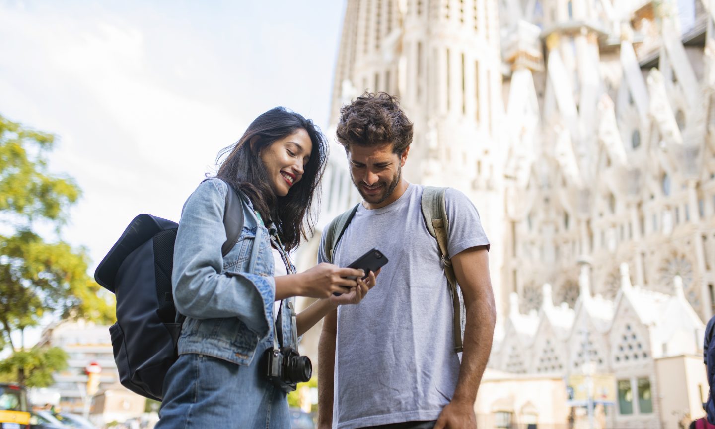 Two travellers looking at a phone together in a city